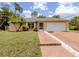 Charming single-story home with a well-maintained lawn, brick driveway, and a two-car garage at 3698 N Chamberlain Blvd, North Port, FL 34286