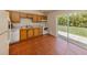 Bright kitchen featuring tiled floors, white appliances, and sliding glass door to yard at 3698 N Chamberlain Blvd, North Port, FL 34286