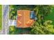 A bird's-eye view captures the orange tile roof and caged pool of the home, set on well manicured grounds by the water at 387 Eden Dr Dr, Englewood, FL 34223