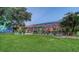 Spacious backyard features a well-maintained lawn, screened pool area, and lush landscaping for outdoor enjoyment at 387 Eden Dr Dr, Englewood, FL 34223