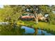 Waterfront backyard featuring lush greenery, a spacious patio, and mature trees offering ample shade at 387 Eden Dr Dr, Englewood, FL 34223