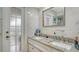 Bathroom features marble countertops with dual sinks and a glass door to the outside at 387 Eden Dr Dr, Englewood, FL 34223