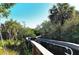 Scenic boardwalk winding through lush greenery with clear blue skies, nature-filled walkway, palm trees, and great views at 387 Eden Dr Dr, Englewood, FL 34223