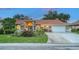 Attractive home showcasing a red tile roof, well-maintained lawn, and an expansive driveway at 387 Eden Dr Dr, Englewood, FL 34223