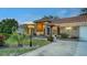 Well-lit home with a red tile roof, beautiful landscaping, and a spacious driveway at 387 Eden Dr Dr, Englewood, FL 34223