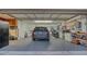 Spacious garage with an automatic door, equipped with storage cabinets, a workbench and parked car at 387 Eden Dr Dr, Englewood, FL 34223
