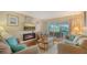 Cozy living room with comfortable seating, a decorative fireplace, and a view of the outdoor pool area at 387 Eden Dr Dr, Englewood, FL 34223