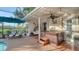 Relaxing screened-in patio with a hot tub, egg chair, and lounge chairs at 387 Eden Dr Dr, Englewood, FL 34223