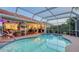 Screened pool is situated near an outdoor kitchen and dining area, perfect for entertaining guests at 387 Eden Dr Dr, Englewood, FL 34223