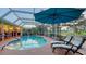 Inviting screened pool with patio seating and a lush, landscaped view beyond the enclosure at 387 Eden Dr Dr, Englewood, FL 34223
