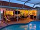 Covered outdoor entertaining space featuring a built-in grill, seating, and pool at 387 Eden Dr Dr, Englewood, FL 34223