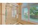 Shower with frameless glass doors and a window view at 387 Eden Dr Dr, Englewood, FL 34223