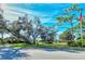 A scenic street view overlooking lush greenery, mature trees, and a well-maintained lawn with walking path at 387 Eden Dr Dr, Englewood, FL 34223