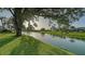 Picturesque view of a serene pond framed by lush greenery and mature trees at 387 Eden Dr Dr, Englewood, FL 34223