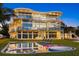 Beautiful view of the expansive modern house with large windows, a pool, and lounge chairs on a grassy lawn at 4035 Bay Shore Rd, Sarasota, FL 34234