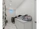Bright laundry room featuring marble floors, washer and dryer, and storage cabinets at 4035 Bay Shore Rd, Sarasota, FL 34234