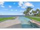 A lavish outdoor pool offers a bar with stools and chairs on the adjacent green space at 4035 Bay Shore Rd, Sarasota, FL 34234