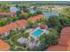 Aerial view of community featuring a pool, green spaces, and serene lake at 4037 Crockers Lake Blvd # 24, Sarasota, FL 34238