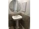 Powder room featuring pedestal sink with decorative mirror and tiled walls at 4037 Crockers Lake Blvd # 24, Sarasota, FL 34238