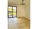 Sunlit bedroom with wood-look flooring and a sliding glass door to a balcony at 4037 Crockers Lake Blvd # 24, Sarasota, FL 34238