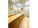 Bathroom with extended wood vanity featuring a mirror, and a patterned shower curtain at 4042 S Lockwood Ridge Rd, Sarasota, FL 34231