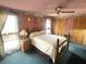Cozy bedroom featuring a vintage bedframe, neutral carpeting, and decorative wallpaper border at 4042 S Lockwood Ridge Rd, Sarasota, FL 34231