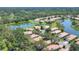 Aerial view of houses on a lake, with mature trees and lush greenery in the neighborhood at 4121 Reflections Pkwy, Sarasota, FL 34233