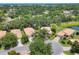 Aerial view of a neighborhood featuring well-maintained homes, mature trees, and a tranquil pond at 4121 Reflections Pkwy, Sarasota, FL 34233