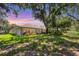 Beautiful backyard with lush greenery, mature trees, and a screened-in patio for outdoor living at 4121 Reflections Pkwy, Sarasota, FL 34233