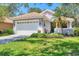 Charming single-story home with a tile roof, a two-car garage, and a well-manicured front yard at 4121 Reflections Pkwy, Sarasota, FL 34233