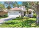 Charming single-story home with a tile roof, a two-car garage, and a well-manicured front yard at 4121 Reflections Pkwy, Sarasota, FL 34233