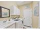Functional laundry room with sink, washer, dryer, and white cabinets at 4121 Reflections Pkwy, Sarasota, FL 34233
