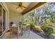 Beautiful screened-in patio with table set and views of the meticulously maintained landscaping at 4121 Reflections Pkwy, Sarasota, FL 34233