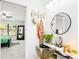 Stylish bathroom vanity with a round mirror, decorative accessories, and view to a bedroom at 4253 Prairie View Dr, Sarasota, FL 34232