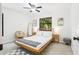 Bright bedroom with a wooden bed frame, tropical decor, and a lush green view outside the window at 4253 Prairie View Dr, Sarasota, FL 34232