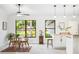 Bright kitchen area with white cabinetry, a breakfast bar, and a dining area with a scenic view at 4253 Prairie View Dr, Sarasota, FL 34232