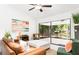 Bright living room featuring a leather sofa, modern décor, and screened patio access at 4253 Prairie View Dr, Sarasota, FL 34232
