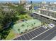 Aerial view of the tennis court surrounded by palm trees and a parking lot at 4310 Falmouth Dr # 307, Longboat Key, FL 34228