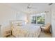 Cozy bedroom featuring a wicker bed frame, ceiling fan, and lots of natural light at 4310 Falmouth Dr # 307, Longboat Key, FL 34228
