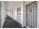 An exterior shot of a condo unit featuring a doorway and a long, well-lit hallway with railings at 4310 Falmouth Dr # 307, Longboat Key, FL 34228