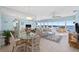 Bright living room with water views, neutral tile flooring, dining area, comfortable seating, and floor-to-ceiling mirrors at 4310 Falmouth Dr # 307, Longboat Key, FL 34228