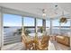 Bright sunroom with tile floors and large sliding glass doors overlooking a beautiful bay, complete with table and seating at 4310 Falmouth Dr # 307, Longboat Key, FL 34228