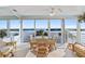 Bright sunroom with tile floors and large sliding glass doors overlooking a beautiful bay, complete with table and seating at 4310 Falmouth Dr # 307, Longboat Key, FL 34228