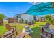 Cozy backyard featuring a fire pit, Adirondack chairs, a grill, and a shade umbrella perfect for outdoor relaxation at 440 42Nd N St, St Petersburg, FL 33713