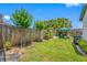 Grassy backyard with a blue umbrella, grill, and wooden fence at 440 42Nd N St, St Petersburg, FL 33713
