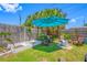 Inviting backyard featuring a blue umbrella, seating, and lush green grass at 440 42Nd N St, St Petersburg, FL 33713
