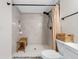 Walk-in shower featuring neutral tile surround, wood bench, and black fixtures at 440 42Nd N St, St Petersburg, FL 33713
