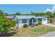 Charming single-story home featuring white siding, green trim, and well-maintained front yard landscaping at 440 42Nd N St, St Petersburg, FL 33713