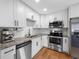 Modern kitchen featuring stainless steel appliances, granite countertops, and white cabinets with black hardware at 440 42Nd N St, St Petersburg, FL 33713