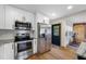 Bright kitchen with stainless steel appliances, white cabinets and access to bonus room with a barn door at 440 42Nd N St, St Petersburg, FL 33713